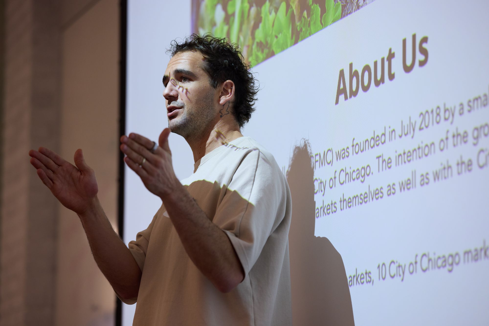 Andre stands in front of the projector screen, speaking.